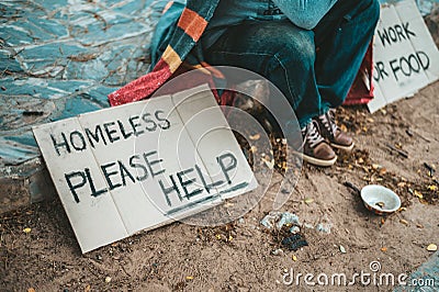 A man sitting beggars with homeless please help message Stock Photo