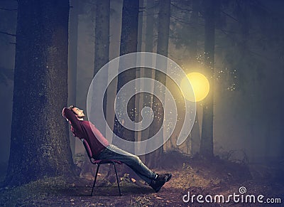 Man sitting on chair in the forest Stock Photo