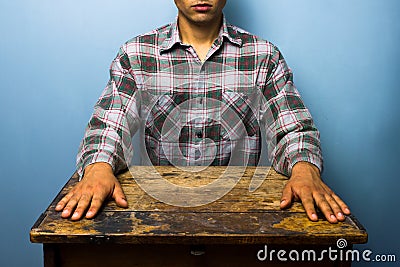 Man sitting at desk in a tense pose Stock Photo