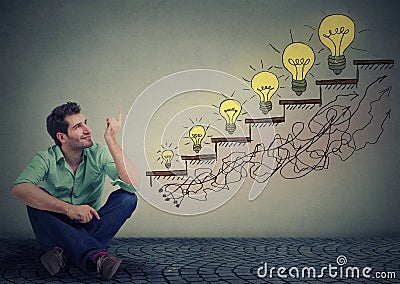 Man sitting on floor in office pointing at business education success, promotion, company growth Stock Photo