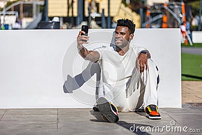 Man Sitting on the Ground Taking a Selfie Stock Photo