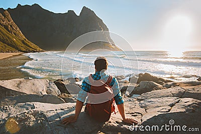 Man sitting on Kvalvika beach enjoying ocean view travel vacations eco tourism Stock Photo