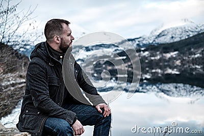 Man sitting near Hardangerfjord, Norway. Stock Photo