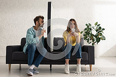 Man sitting near model of smartphone and addicted girlfriend chatting Stock Photo