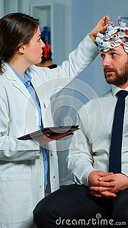 Man sitting on neurological chair with brainwave scanning headset Stock Photo
