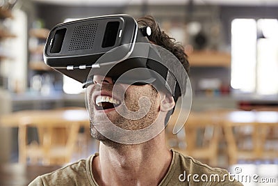 Man Sitting On Sofa Wearing Virtual Reality Headset Stock Photo