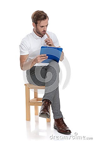 Man sitting and solving a difficul problem on his clipboard Stock Photo