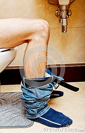 Man sitting on a toilet seat Stock Photo