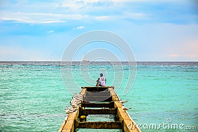 A man sitting on top of a pier surrounded by seagulls observes t Editorial Stock Photo