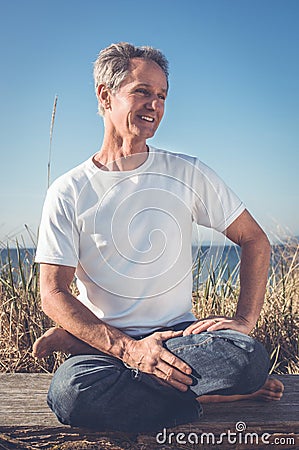 Man sitting in yoga pose. Stock Photo