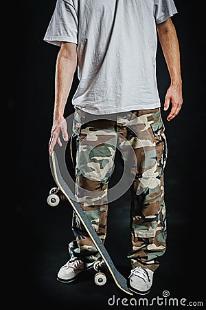 Man with skateboard on a black background Stock Photo