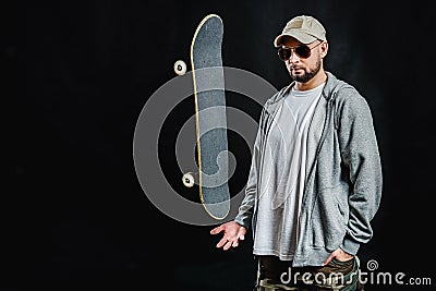 Man with skateboard on a black background Stock Photo