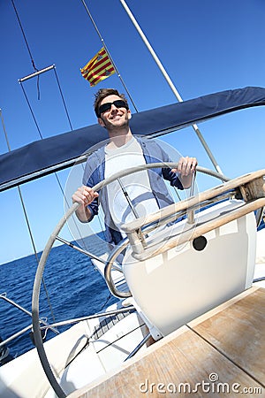 Man skipper navigating a sailing boat Stock Photo