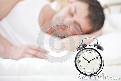 Man sleeping with alarm clock Stock Photo