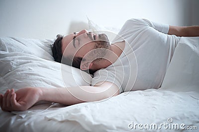 Man sleeping in his bed and snoring loudly Stock Photo