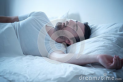 Man sleeping in his bed and snoring loudly Stock Photo