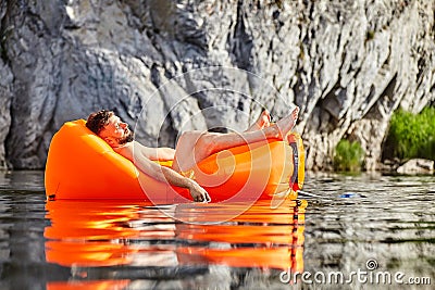 Man sleeping in a raft on the river Stock Photo