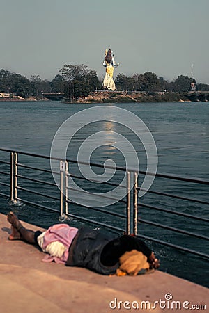 Man sleeping under Lord Shiva`s feet Editorial Stock Photo