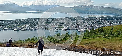 Snow on the top of the Mount Storsteinen in summer and panoramic view of Tromso city in Norway. Editorial Stock Photo