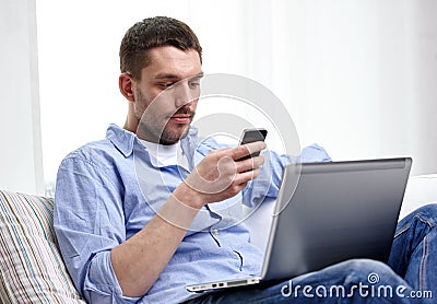 Man with smartphon and laptop computer at home Stock Photo