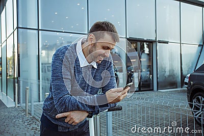 Man with smartphone in front of the glass facade Stock Photo