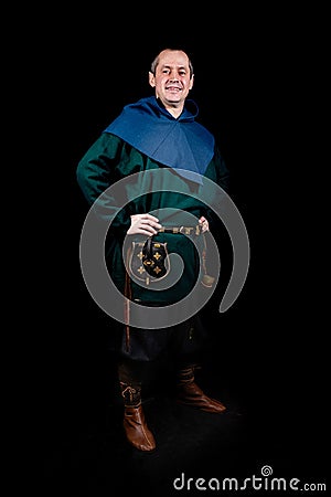 A man smiles and poses in ancient Viking clothing, hands on hips. Full height portrait. Security, protection. Stock Photo