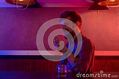 The man smoke an electronic cigarette at the vape shop. Stock Photo