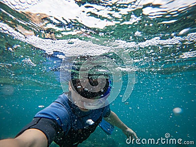 Man in snorkel mask doing selfie underwater. Adventure and travel concept. Stock Photo
