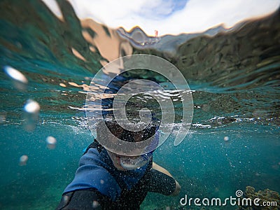 Man in snorkel mask doing selfie underwater. Adventure and travel concept. Stock Photo