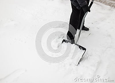 Man with snow shovel cleans sidewalks Stock Photo