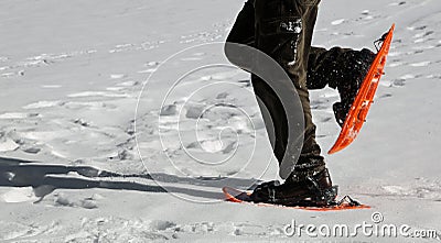 Man snowshoeing with orange snowshoes Stock Photo