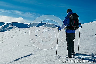 Kor Alps - Man in snowshoes on the way to majestic summit peak Grosser Speikogel in Kor Alps, Lavanttal Alps Stock Photo