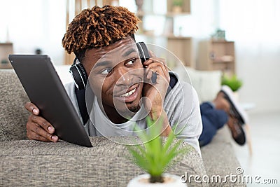 man on sofa with digital tablet and headphone Stock Photo