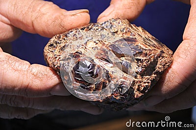 Man sorting and valuing raw garnet gemstone Stock Photo