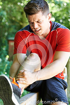 Man With Sports Injury Sustained Whilst Exercising Outdoors Stock Photo