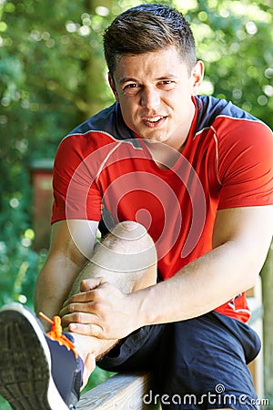 Man With Sports Injury Sustained Whilst Exercising Outdoors Stock Photo