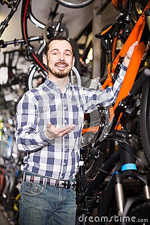 Man in sports workshop mounts bike using special tools Stock Photo