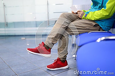 Man in sportswear is waiting on chair in hallway Stock Photo