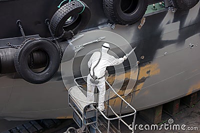 Man spray painting hood of ship Stock Photo