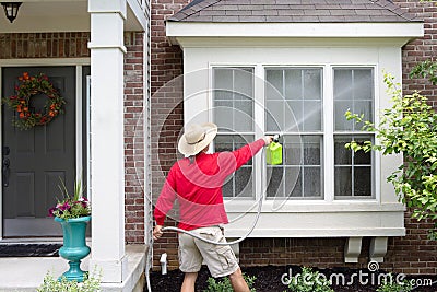 Man spring cleaning the exterior of his house Stock Photo
