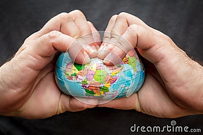 Man squeezing a globe, symbolic of flat earth, concept of conspiracy theory Stock Photo