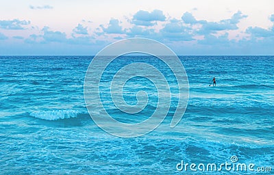 Man stand paddling in the ocean during sunset at Cancun, Yucatan, Mexico Stock Photo