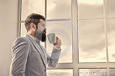 Man stand at window nervous about wedding. Life choices and expectations. But first coffee. His big day. Wedding morning Stock Photo