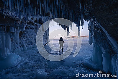 A man standing on Baikal frozen lake in front of ice cave, winter season in Siberia, Russia Stock Photo