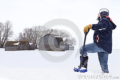 Man standing in deep snow with shovel in hand. Stock Photo