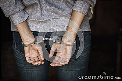 Man is standing with his back on his hands handcuffs are on Stock Photo