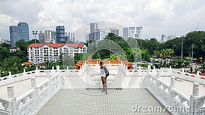 a man standing inside Thean Hou Temple facing the view of Kuala Lumpur skyscrapers Editorial Stock Photo