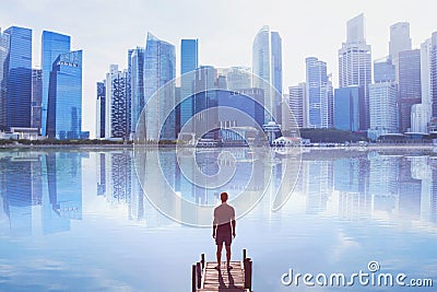 Man standing on the pier looking at modern cityscape skyline Stock Photo