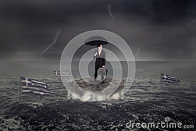 Man standing on the rock with Greece flag sink on the sea Stock Photo