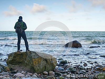 Man standing on rock in the middle of ocean. Tourist stand alone Stock Photo